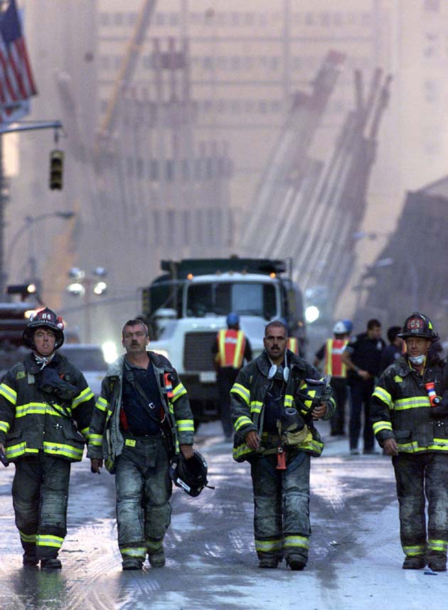 Firefighters walk up Church Street and away from the remains of the World Trade Center towers in New York, early September 12, 2001. Both towers were destroyed after being struck by planes September 11
