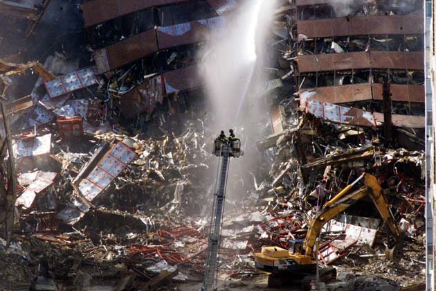 New York City firefighters pour water on the wreckage of 7 World Trade Center in New York City early September 12, 2001. 7 World Trade Center was destroyed along with both the landmark WorldTrade Center towers after being struck by planes in a terrorist attack on September 11.