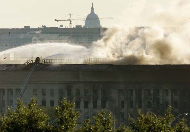 The US Capitol is seen behind the Pentagon as it continues to burn September 12, 2001, a day after a highjacked airliner crashed into the building. Three hijacked planes crashed into major US landmarks September 11, destroying both of New York's mighty twin towers and plunging the Pentagon in Washington into flames.