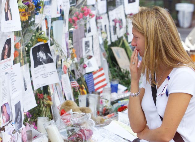 A woman looks at posters listing the missing at a memorial in Union Square in New York, September 18, 2001 one week after the attacks in New York and Washington.