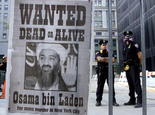 New York police stand near a wanted poster printed by on a full page of a New York newspaper for Saudi-born militant Osama bin Laden in the financial district of New York, in this file photo from September 18, 2001. Osama bin Laden was named by US President George W Bush as the prime suspect in the attacks in New York and Washington. This year's anniversary of the September 11 attacks in New York and Washington will echo the first one, with silence for the moments the planes struck and when the buildings fell, and the reading of 2,792 victims' names.