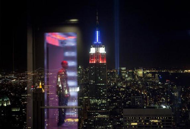 A reflection can be seen on a glass barrier in the Top Of The Rock observation deck in front of the Tribute in Light memorial shining behind the Empire State Building marking the ninth anniversary of the September 11 attacks on the World Trade Center in New York September 11, 2010.