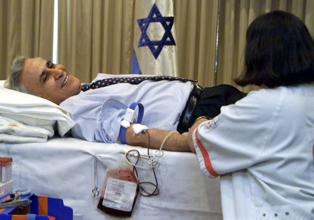 Israeli President Moshe Katsav donates blood in his Jerusalem residence September 12, 2001, for the victims of yesterday's terrorist attacks in the United States. Israel has declared a national day of mourning in solidarity with the US after devastating aircraft attacks in New York and Washington DC Flags flew at half-mast across the Jewish state as Israel expressed its sorrow over the unprecedented assault on its main ally while scores of Israelis and others donated blood.