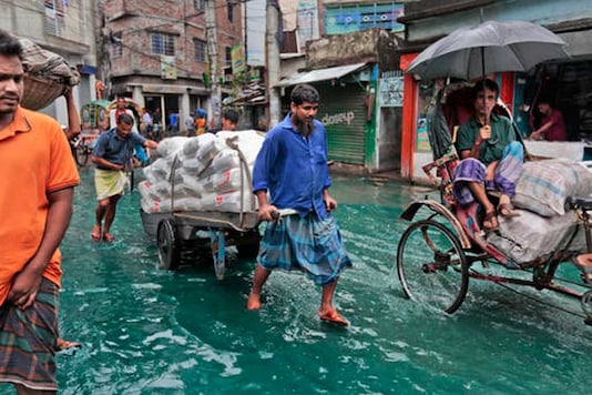 Bangladeshi men pull a loaded cart through a waterlogged street after heavy rainfall in Dhaka. (AP) Bangladeshi men pull a loaded cart through a waterlogged street after heavy rainfall in Dhaka. (AP)