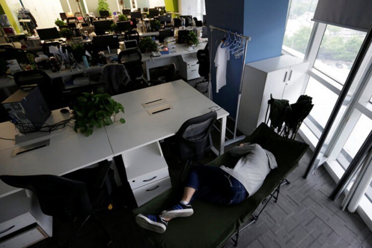 The Wider Image: Working, eating and sleeping at the office