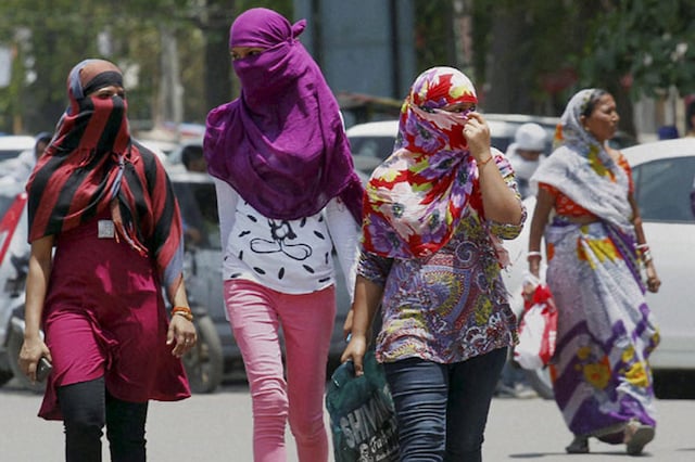 Girls cover their faces to beat the heat on a hot day. (File Photo/PTI) 
