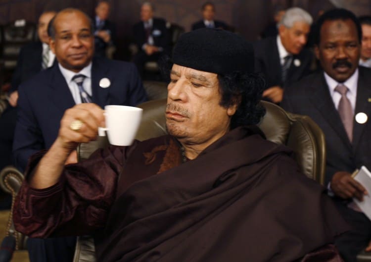 Libyan leader Muammar Gaddafi drinks during the opening of the two-day Arab Summit in Damascus
