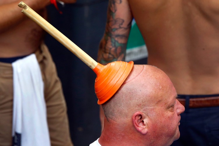 15. An England fan wears a sink plunger on his head in Saint Etienne. 