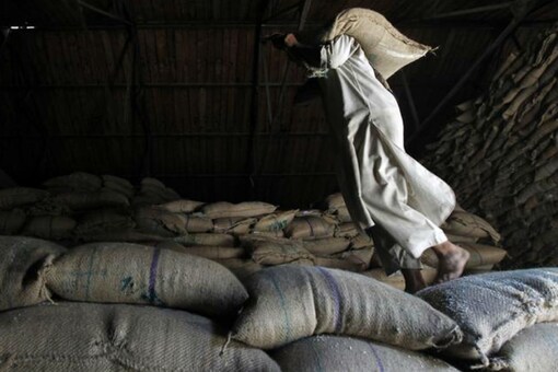 For representation: A labourer carries a sack containing rice on his shoulder.
