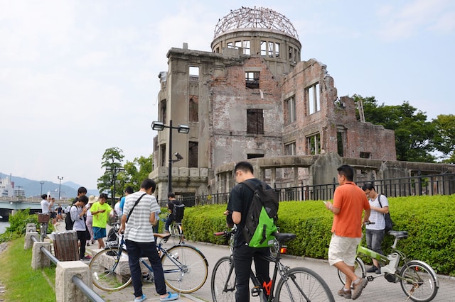 In this July 26, 2016 photo, people play Pokemon Go near the Atomic Bomb Dome at Hiroshima Peace Memorial Park in Hiroshima, Japan. Image: Kyodo News via AP