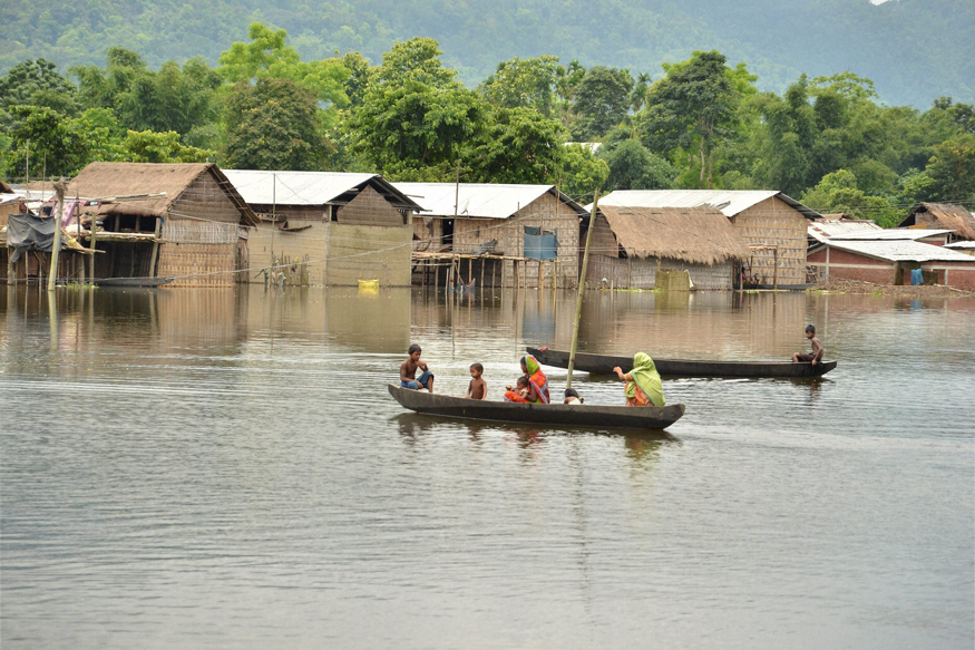  Villagers commute by rowing boats in a flooded village near Kaziranga National Park. (PTI)