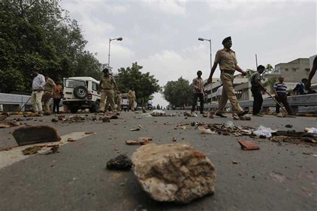 Policemen remove stones put by members of Dalit community to block traffic during their protests in Ahmedabad. (AP)