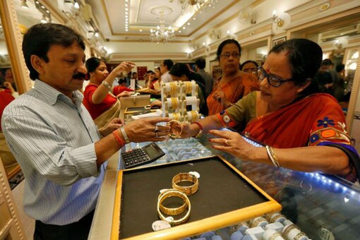 A salesman shows gold bangles to a customer at a jewellery  showroom. (Reuters) Representative image