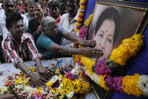 Supporters of Jayalalithaa pay tributes near her photograph outside their party office in Mumbai on December 6, 2016. (AP Photo)