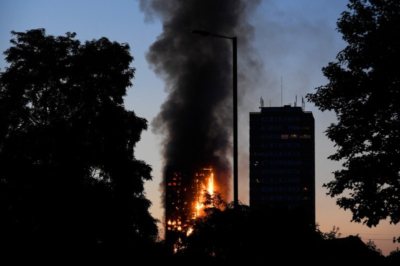 Flames and smoke billow as firefighters deal with a serious fire in a tower block at Latimer Road in West London