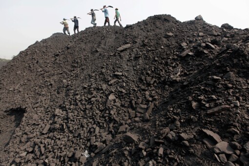 Workers walk on a heap of coal at a stockyard of an underground coal mine in the Mahanadi coal fields at Dera, near Talcher town in Odisha.  Image for representation. (Photo: Reuters)