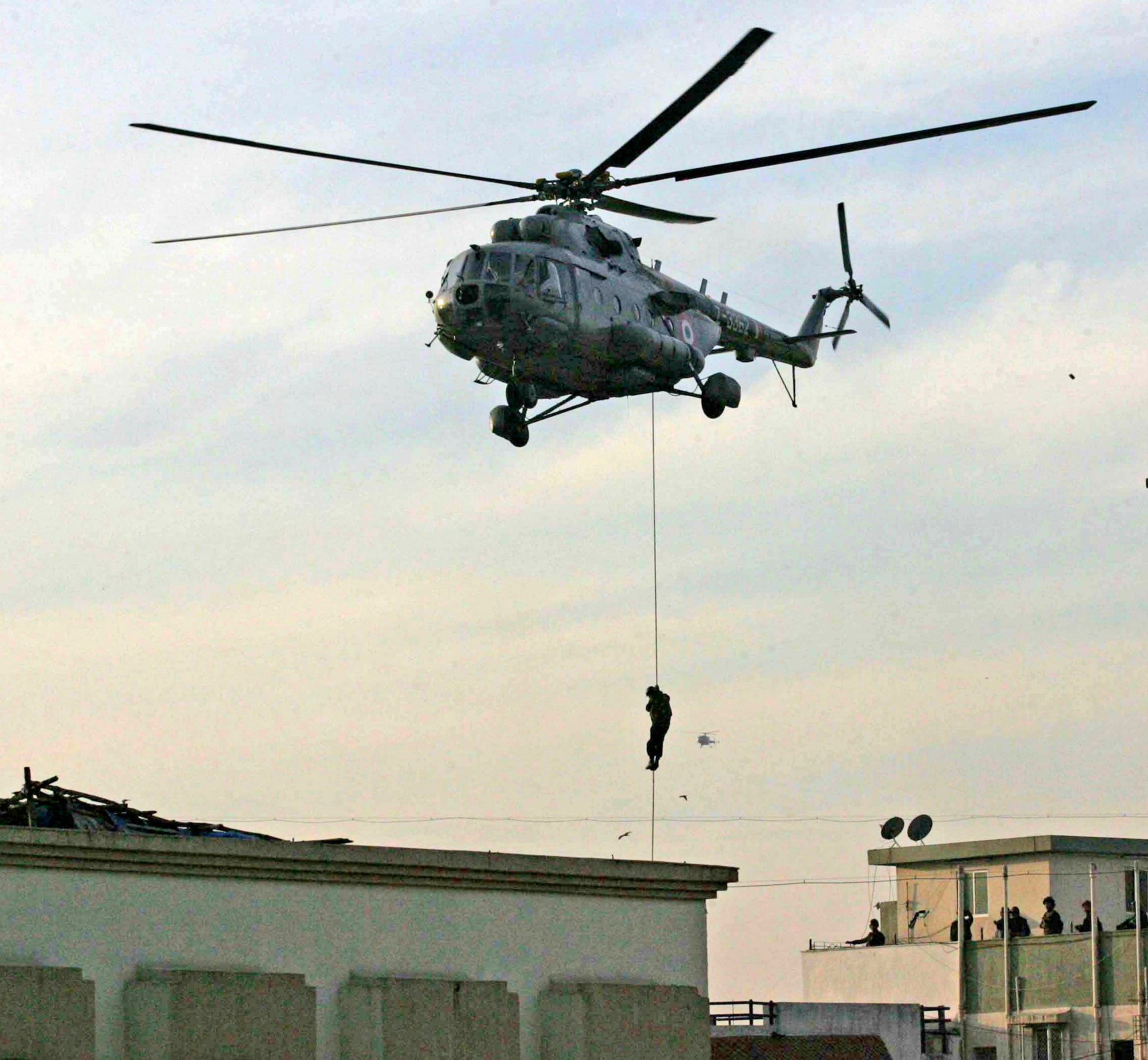 A National Security Guard (NSG) commando rappels from a helicopter near Nariman House where suspected militants are believed to be hiding, in Mumbai November 28, 2008. Indian commandos stormed a Jewish centre in Mumbai on Friday evening, killing two Islamist gunmen but failing to save five hostages, after two days of bloodshed that have created fresh tensions with old foe Pakistan. REUTERS/Stringer (INDIA) - RTXB1ZE