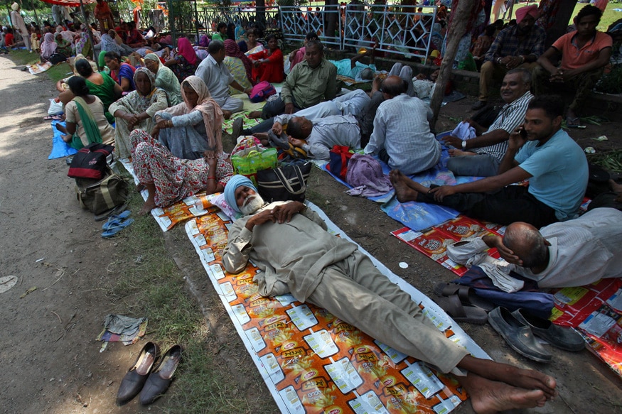 Supporters of Gurmeet Ram Rahim Singh rest as they gather near a stadium in Panchkula