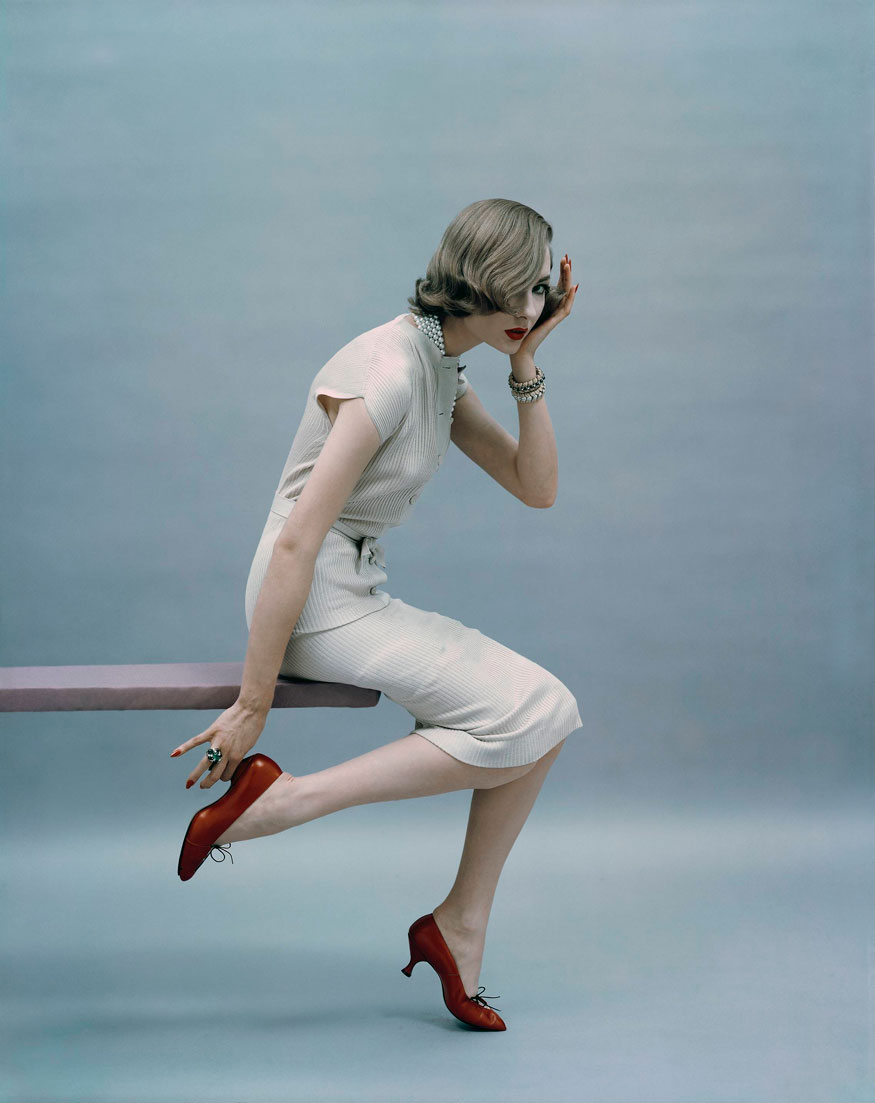 10. Vogue 1957 - Model in knitted, silk, ribbed dress with hand on heel. 