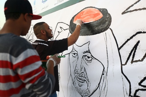 File photo of Saudi men paint a mural depicting late Saudi Arabia's Foreign Minister Prince Saud al-Faisal  in Jeddah. Image: Reuters 