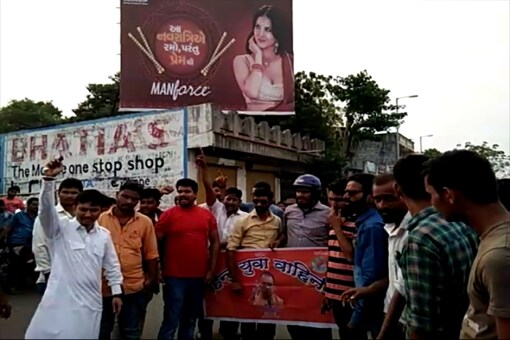 Hindu Yuva Vahini activists protesting in front of the hoarding featuring a condom ad with Sunny Leone.