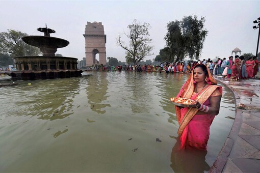 A Devotee performs rituals on the occasion of Chhath puja at India Gate pond, in New Delhi on October 26, 2017. (Image: PTI)