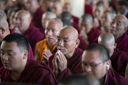 Exile Tibetan Buddhist monks listen to a religious talk by their spiritual leader the Dalai Lama, unseen, at the Tsuglakhang temple in Dharmsala. (Image: AP)