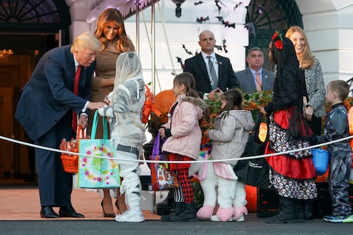 President Donald Trump and first lady Melania Trump hand out treats as they welcome children from the Washington area and children of military families to trick-or-treat celebrating Halloween at the South Lawn of the White House in Washington. (AP Photo)