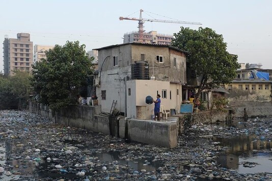 A woman holds plastic buckets after washing her clothes outside her house next to a canal filled with garbage at a slum in Mumbai. (Photo: Reuters/Danish Siddiqui) A woman holds plastic buckets after washing her clothes outside her house next to a canal filled with garbage at a slum in Mumbai. (Photo: Reuters/Danish Siddiqui)