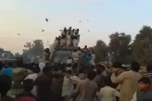 A video showing the groom's family standing at the top of a bus and throwing gifts towards the guests. (Photo: YouTube grab)
