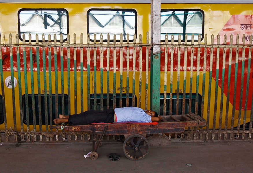 A porter sleeps on a handcart at a railway platform in Kolkata. (Image: Reuters)