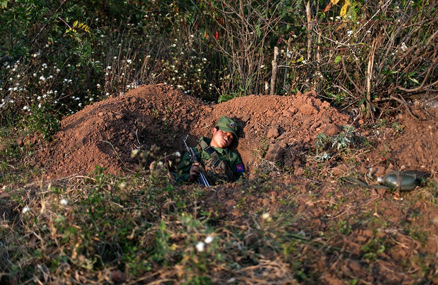 A rebel soldier of the Myanmar National Democratic Alliance Army (MNDAA) sleeps with his rifle inside a trench near a military base in Kokang region. (Image: Reuters)