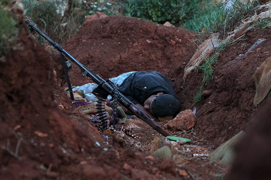 A rebel fighter takes a nap as he rests along a trench at the front-line where the rebel fighters announced the start of an offensive to take control of Ariha town from forces loyal to Syria's President Bashar al-Assad, in Idlib. (Image: Reuters)