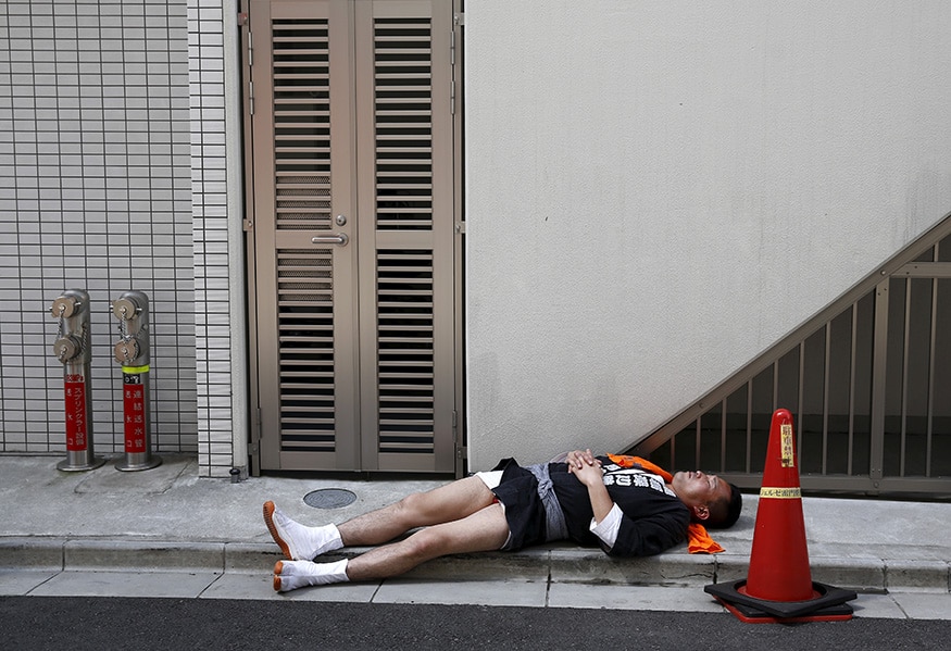 A man is seen sleeping on the pavement in the Asakusa district of Tokyo. (Image: Reuters)