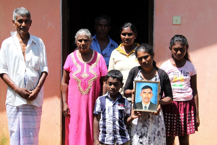 Family of H.G Kumarsinghe hold a portrait of the man whose death at the hands of three Muslim men sparked the rioting in Kandy