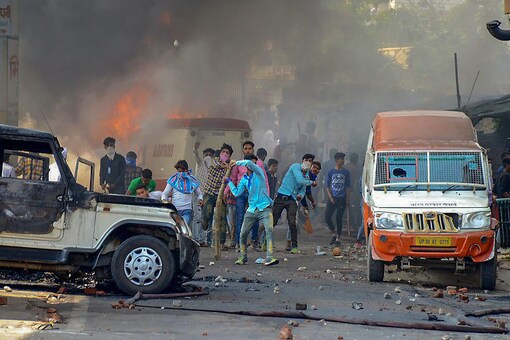 Protesters hurl brickbats as smoke billows out of burning cars during 'Bharat Bandh' against the alleged 'dilution' of Scheduled Castes/Scheduled Tribes act, in Muzzaffarnagar.  (PTI Photo)