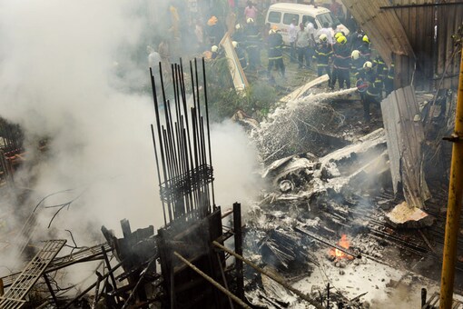 Firemen try to douse the smouldering remains of the chartered plane that crashed in Ghatkopar's Jivdaya Lane on June 28. (PTI Photo)