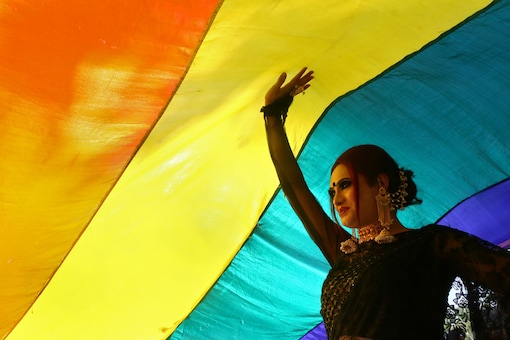 A participant walks under a rainbow flag during a pride parade in 2018. (Image: Reuters