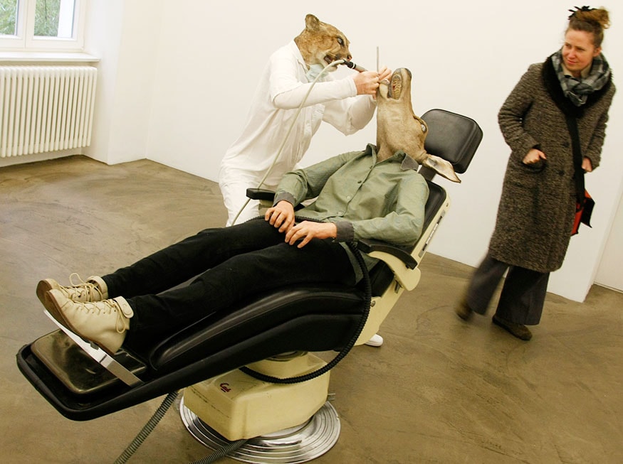 A visitor passes behind the sculpture 'Puma-Dentist' made with plastic, wax and original heads of a puma and a hind by Austrian artist Deborah Sengl during an exhibition at the art gallery Deschler in Berlin. (Image: Reuters)