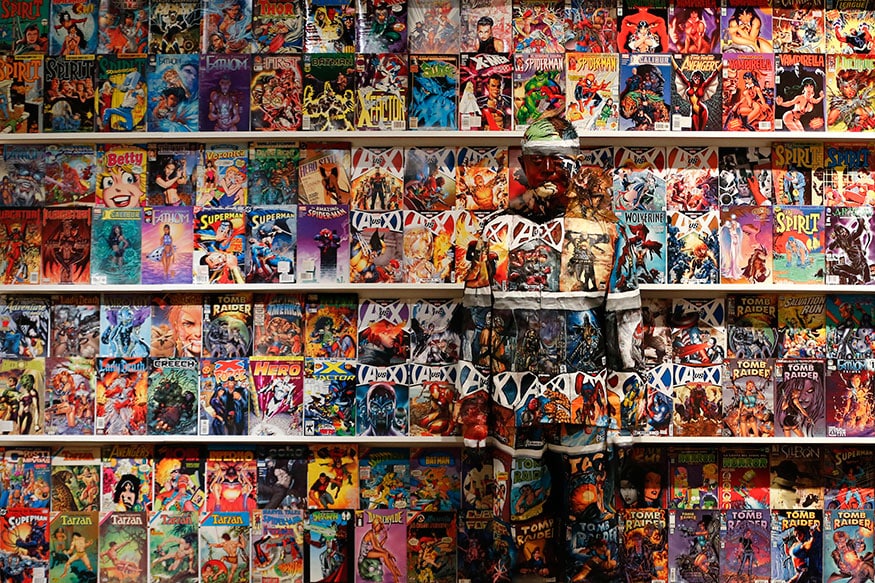 Liu Bolin, a Chinese artist, blends himself into the background in front of a shelf lined with comic books as part of a series of performances in Caracas. Liu, known as