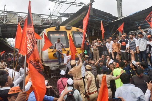 Maratha Kranti Morcha protesters stop a train during their statewide bandh, called for reservations in jobs and education, in Thane. (Image: PTI)