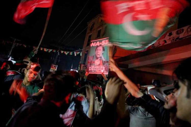 Supporters of Imran Khan, chairman of the Pakistan Tehreek-e-Insaf political party, celebrate near his residence in Bani Gala during the general election, in Islamabad