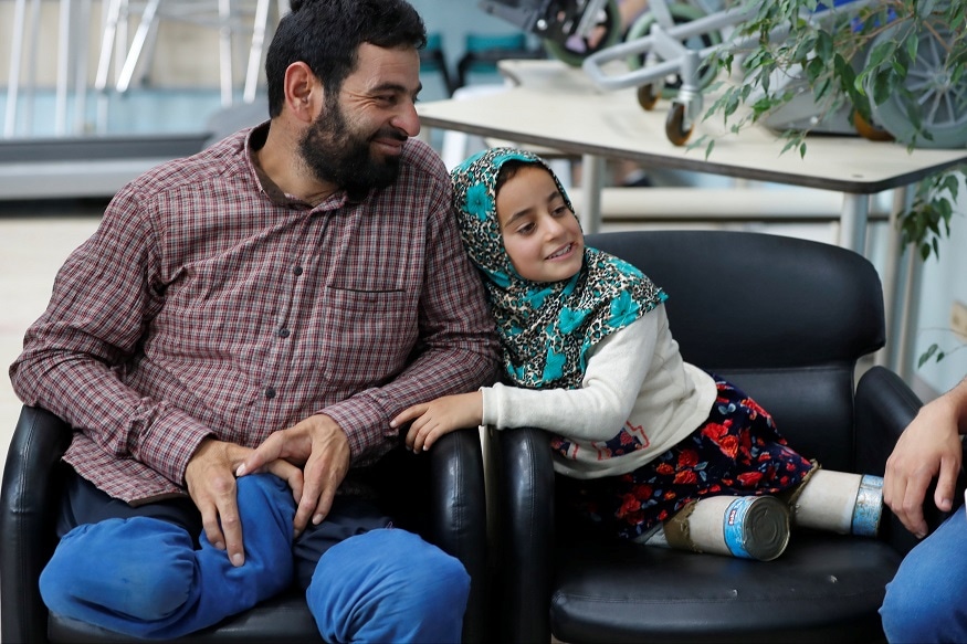 Maya Meri, 8, waits with her father Muhammed Ali Meri at a prosthetic center in Istanbul, Turkey, July 5, 2018. Picture taken July 5, 2018. REUTERS/Osman Orsal