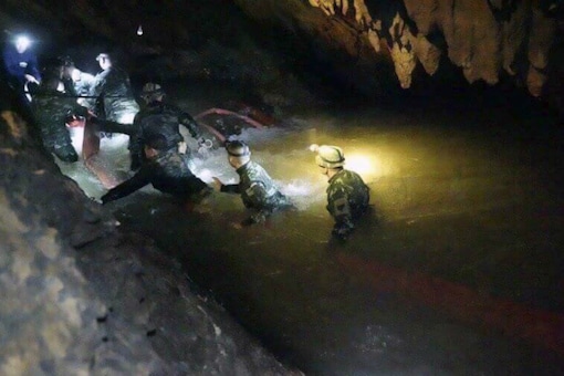In this handout photo released by Tham Luang Rescue Operation Center, Thai rescue teams use headlamps to enter a pitch-black cave complex where 12 boys and their soccer coach went missing, in Mae Sai, northern Thailand on July 2, 2018. (AP)