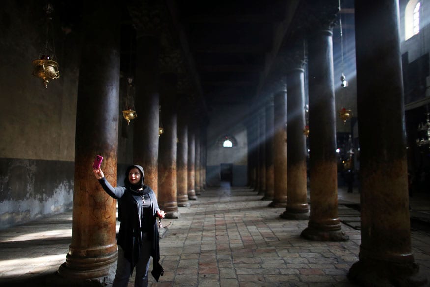 A visitor photographs herself inside the Church of Nativity, the site revered by Christians as Jesus' birthplace in Bethlehem. (Image: Reuters)