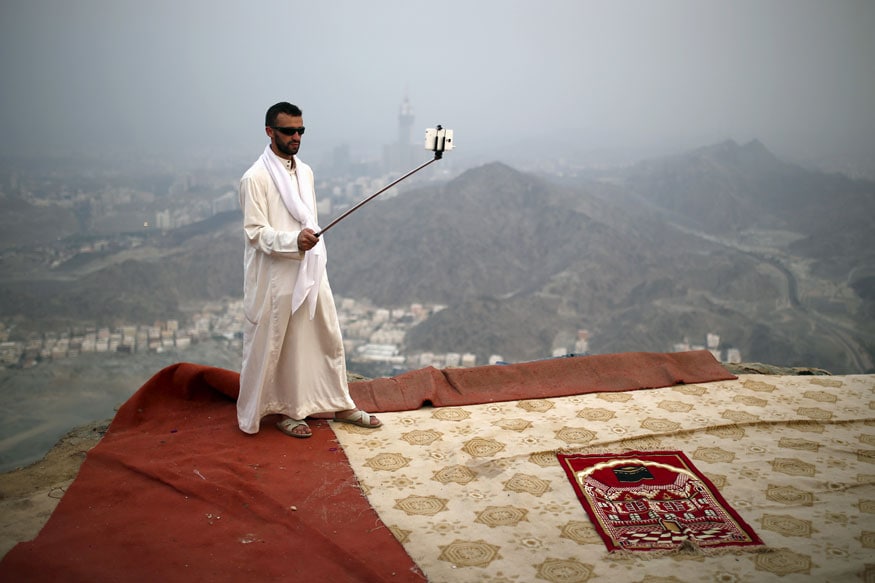 A Muslim pilgrim uses a selfie stick to take pictures atop Mount Thor in the holy city of Mecca. (Image: Reuters)