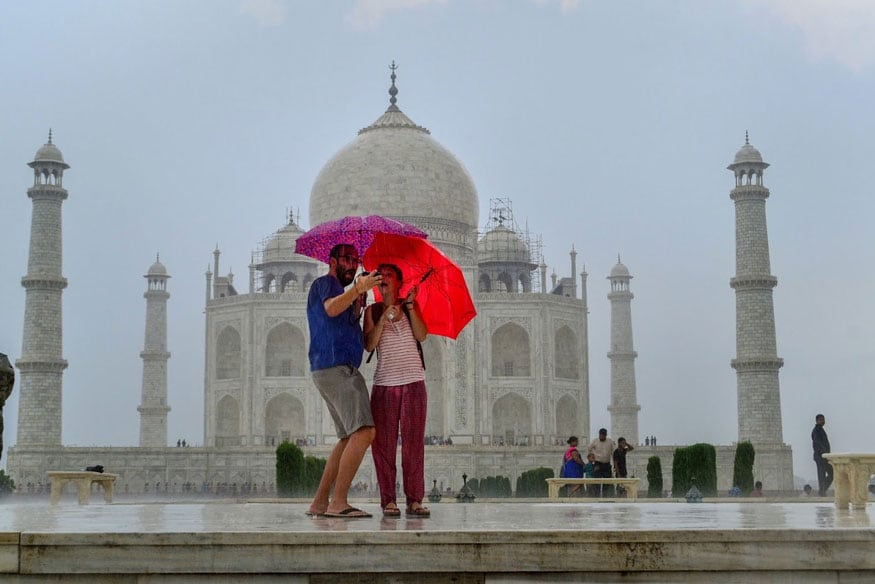 People click a selfie during monsoon rains in front of Taj Mahal in Agra. (Image: PTI)