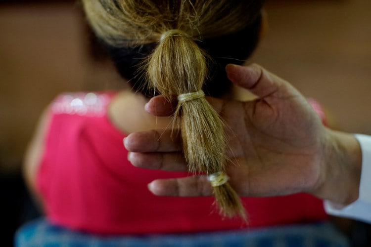 Stylist Sandra Hernandez shows condoms used as as hairbands in her hairdressing salon in Havana