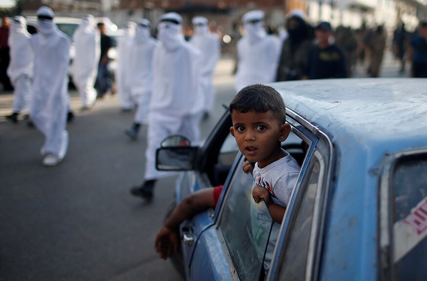 A Palestinian boy looks out a car window as Islamic Jihad militants participate in a military show in Gaza City. (Image: Reuters) A Palestinian boy looks out a car window as Islamic Jihad militants participate in a military show in Gaza City. (Image: Reuters)