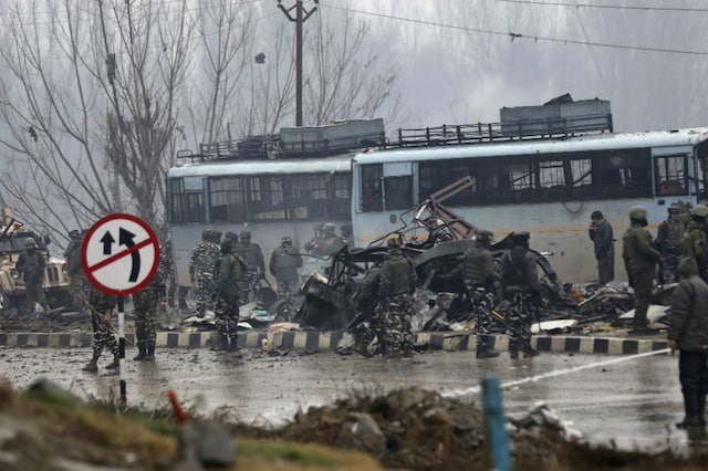 Paramilitary soldiers stand by the wreckage of the CRPF bus after the attack in Kashmir’s Pulwama on Thursday. (AP)